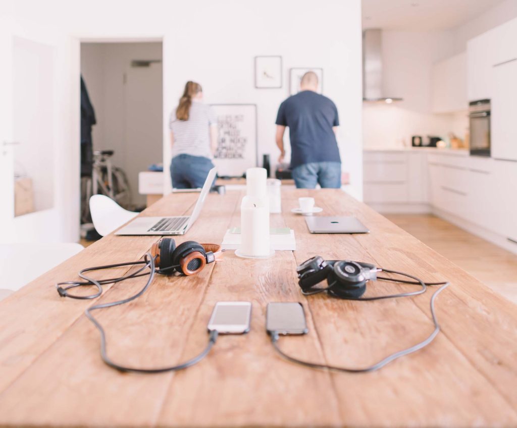 Headphones and devices on wooden table.